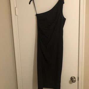 Sleeveless/one-strap form fitting black dress.